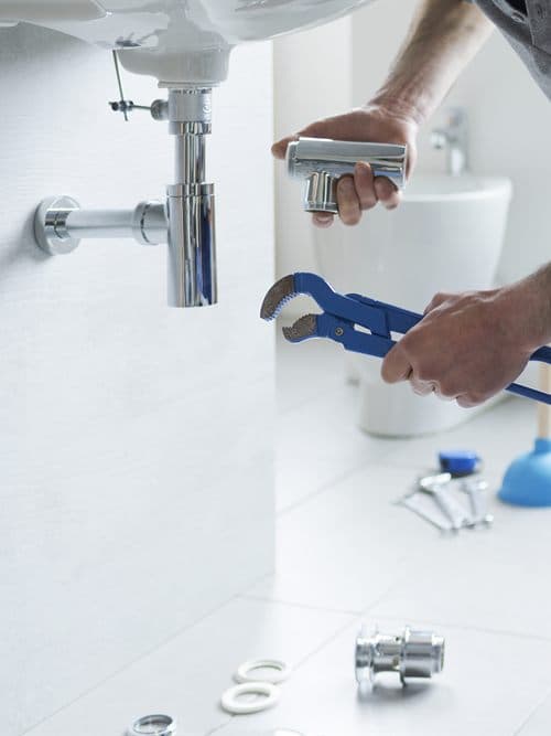 Fontanero de Alberto Luís Gómez Ansia reparando el sifón de un lavabo en Ourense