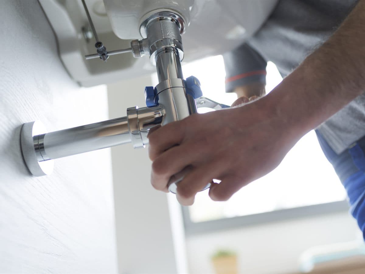 Fontanero de Gómez Ansia ajustando el desagüe de un lavabo en una vivienda de Ourense